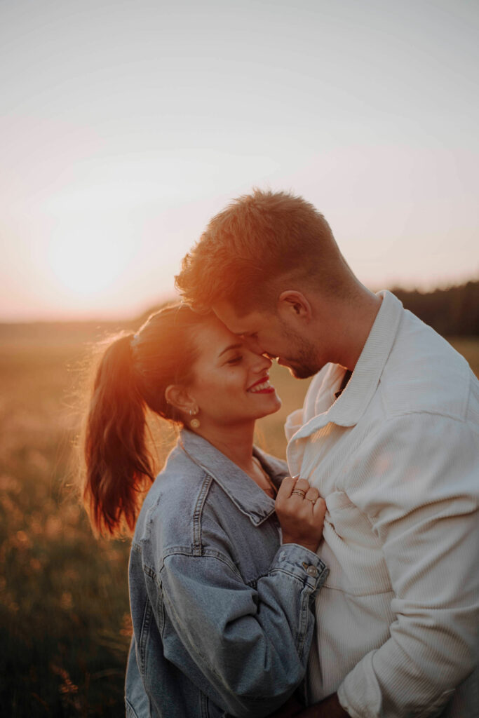 Ein verliebtes Paar wird beim Shooting mit Franziska Angermeier von Franziska´s Fotografie bei Sonnenuntergang festgehalten.